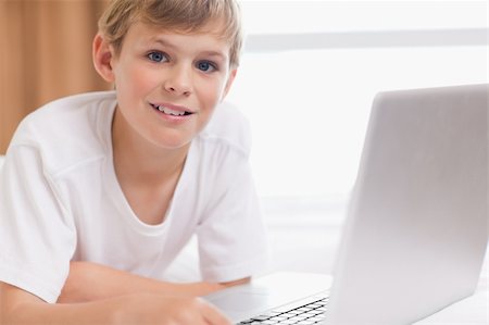 simsearch:400-04129482,k - Smiling boy using a laptop in a bedroom Photographie de stock - Aubaine LD & Abonnement, Code: 400-05749391