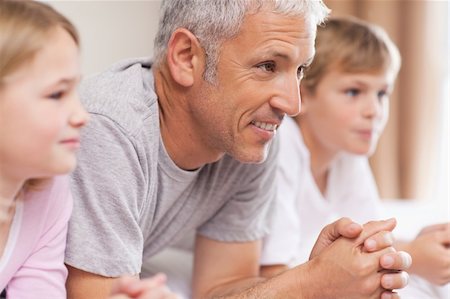 simsearch:400-04195162,k - Father and his children lying on a bed looking away from the camera Foto de stock - Super Valor sin royalties y Suscripción, Código: 400-05749392