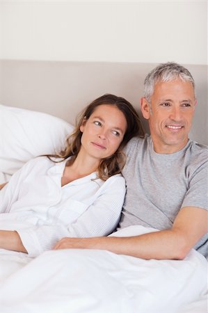 simsearch:400-05749447,k - Portrait of a happy couple lying on a bed while looking away from the camera Stock Photo - Budget Royalty-Free & Subscription, Code: 400-05749426