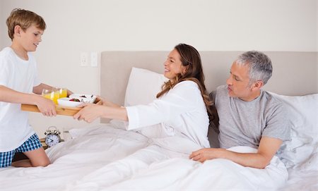 Boy serving breakfast to his parents in their bedroom Foto de stock - Super Valor sin royalties y Suscripción, Código: 400-05749427