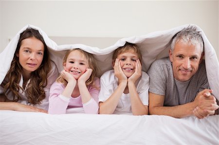 simsearch:400-04198260,k - Family lying under a duvet in a bedroom Stock Photo - Budget Royalty-Free & Subscription, Code: 400-05749438