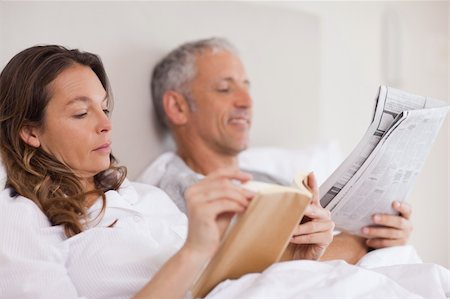 simsearch:400-05749447,k - Woman reading a book while her husband is reading a newspaper in their bedroom Stock Photo - Budget Royalty-Free & Subscription, Code: 400-05749449