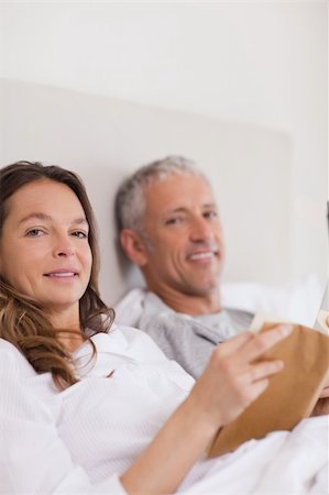 simsearch:400-05749447,k - Portrait of a woman reading a book while her husband is reading the news in their bedroom Stock Photo - Budget Royalty-Free & Subscription, Code: 400-05749453