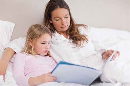 simsearch:400-05749645,k - Cute girl reading a book with her mother in a bedroom Stock Photo - Budget Royalty-Free & Subscription, Code: 400-05749476