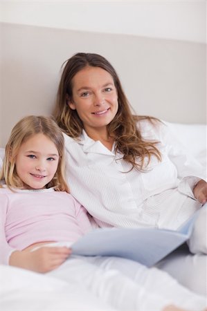simsearch:400-05749645,k - Portrait of a smiling girl reading a book with her mother in a bedroom Stock Photo - Budget Royalty-Free & Subscription, Code: 400-05749478