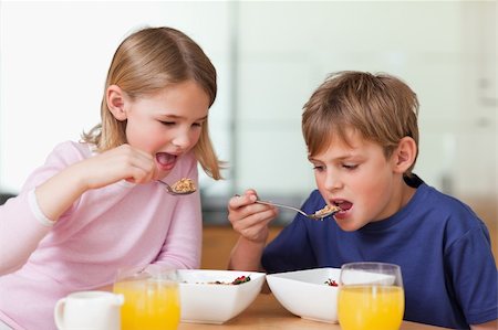 simsearch:400-04218582,k - Young children having breakfast in a kitchen Photographie de stock - Aubaine LD & Abonnement, Code: 400-05749489