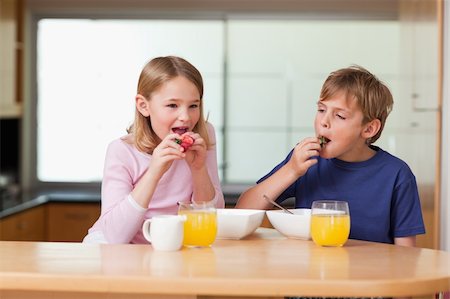 simsearch:400-04218582,k - Children eating strawberries for breakfast in a kitchen Photographie de stock - Aubaine LD & Abonnement, Code: 400-05749494