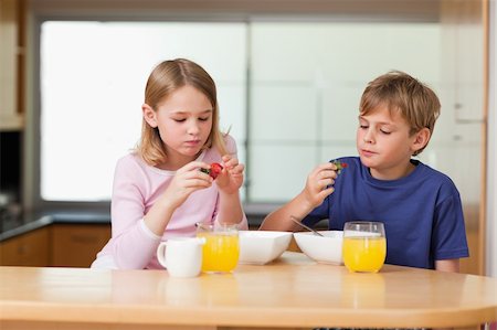 simsearch:400-04218582,k - Cute children eating strawberries for breakfast in a kitchen Stockbilder - Microstock & Abonnement, Bildnummer: 400-05749495