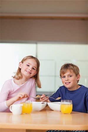 simsearch:400-04218582,k - Portrait of young children having breakfast in a kitchen Photographie de stock - Aubaine LD & Abonnement, Code: 400-05749492
