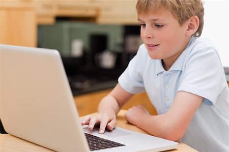 Lovely boy using a laptop in kitchen Photographie de stock - Aubaine LD & Abonnement, Code: 400-05749515