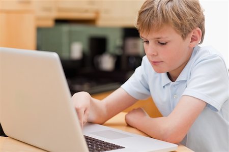 simsearch:400-04044137,k - Focused boy using a laptop in a kitchen Stock Photo - Budget Royalty-Free & Subscription, Code: 400-05749516