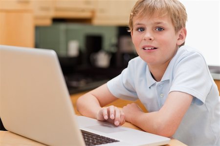 simsearch:400-04044137,k - Lovely boy using a notebook in a kitchen Stock Photo - Budget Royalty-Free & Subscription, Code: 400-05749517