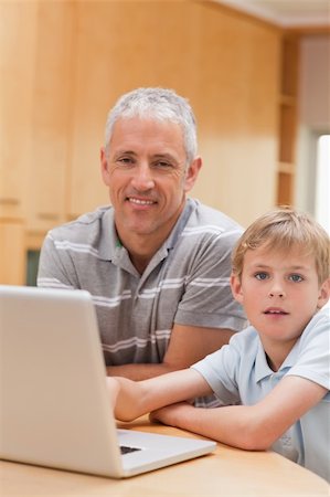 simsearch:400-05748382,k - Portrait of a boy and his father using a laptop in their kitchen Fotografie stock - Microstock e Abbonamento, Codice: 400-05749513