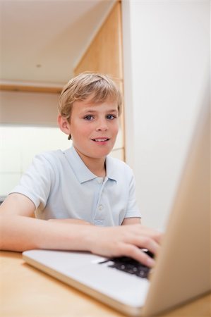 simsearch:400-04044137,k - Portrait of a blond boy using a notebook in a kitchen Stock Photo - Budget Royalty-Free & Subscription, Code: 400-05749523