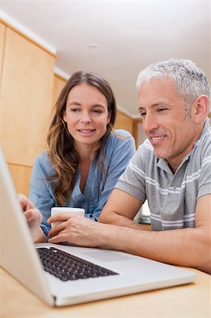 simsearch:400-05741872,k - Portrait of a couple using a laptop while having coffee in their kitchen Stock Photo - Budget Royalty-Free & Subscription, Code: 400-05749544