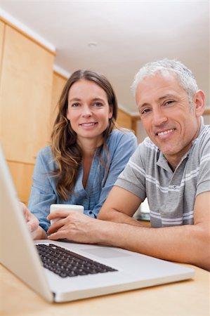 simsearch:400-05749531,k - Portrait of a couple using a laptop while having tea in their kitchen Stock Photo - Budget Royalty-Free & Subscription, Code: 400-05749545