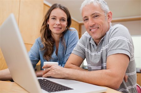 simsearch:400-05741872,k - Couple using a laptop while having tea in their kitchen Stock Photo - Budget Royalty-Free & Subscription, Code: 400-05749546