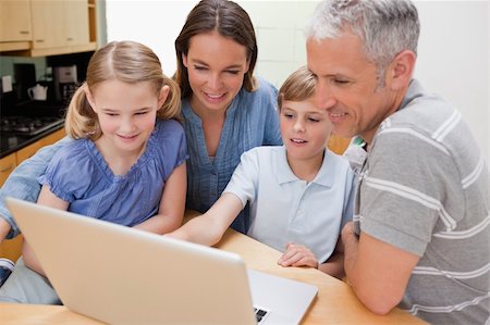 simsearch:400-04654326,k - Lovely family using a notebook in their kitchen Stock Photo - Budget Royalty-Free & Subscription, Code: 400-05749548