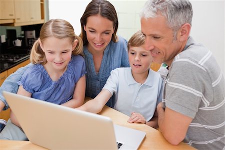 simsearch:400-05748382,k - Lovely family using a notebook in their kitchen Fotografie stock - Microstock e Abbonamento, Codice: 400-05749548