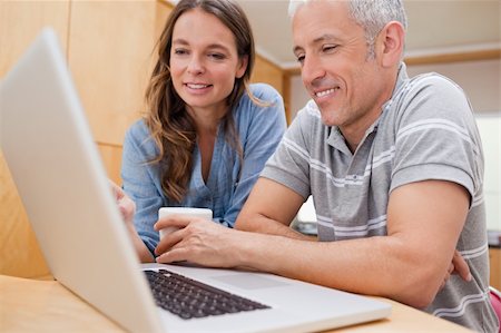 simsearch:400-05741872,k - Couple using a laptop while having coffee in their kitchen Stock Photo - Budget Royalty-Free & Subscription, Code: 400-05749543