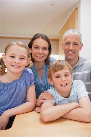 simsearch:400-05749624,k - Portrait of a family posing in a kitchen while looking at the camera Stock Photo - Budget Royalty-Free & Subscription, Code: 400-05749554