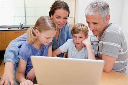 simsearch:400-04654326,k - Charming family using a notebook in their kitchen Stock Photo - Budget Royalty-Free & Subscription, Code: 400-05749550