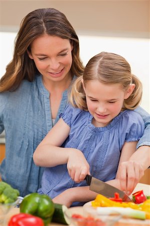 Portrait of a mother slicing bell pepper with her daughter in a kitchen Stock Photo - Budget Royalty-Free & Subscription, Code: 400-05749579