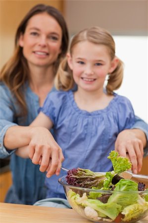 Portrait of a happy woman preparing a salad with her daughter in a kitchen Stock Photo - Budget Royalty-Free & Subscription, Code: 400-05749584