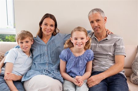 simsearch:400-05749645,k - Happy family sitting on a sofa looking at the camera Stock Photo - Budget Royalty-Free & Subscription, Code: 400-05749594