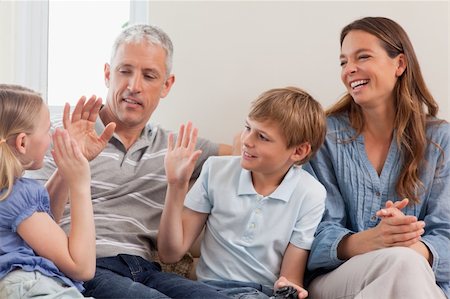 simsearch:400-05749624,k - Cheerful family playing video games in a living room Stock Photo - Budget Royalty-Free & Subscription, Code: 400-05749608