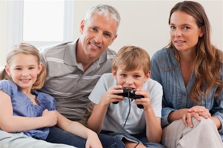 Charming family playing video games in a living room Stock Photo - Budget Royalty-Free & Subscription, Code: 400-05749609