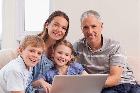 simsearch:400-05749624,k - Happy family sitting on a couch using a laptop in a living room Stock Photo - Budget Royalty-Free & Subscription, Code: 400-05749601