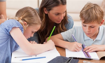 simsearch:400-05882478,k - Mother helping her children to do their homework in a living room Stock Photo - Budget Royalty-Free & Subscription, Code: 400-05749620