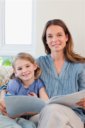 simsearch:400-05749644,k - Portrait of a mother reading a book to her daughter in a living room Stock Photo - Budget Royalty-Free & Subscription, Code: 400-05749644