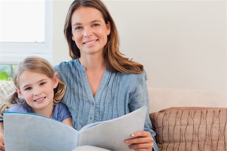 simsearch:400-05749645,k - Happy mother reading a book to her daughter in a living room Stock Photo - Budget Royalty-Free & Subscription, Code: 400-05749645