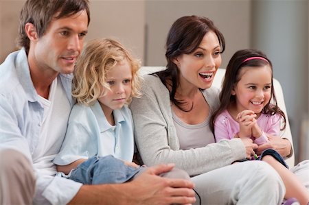 simsearch:400-05749624,k - Cheerful family watching television together in a living room Stock Photo - Budget Royalty-Free & Subscription, Code: 400-05749659