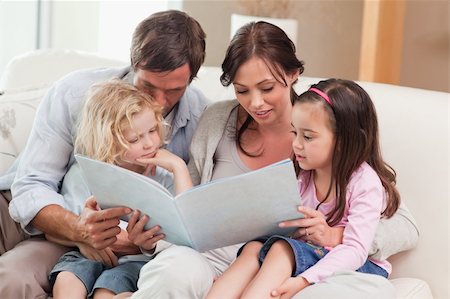 simsearch:632-08227559,k - Family looking at a photo album in the living room Stock Photo - Budget Royalty-Free & Subscription, Code: 400-05749681