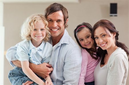 Lovely family posing while looking at the camera Stock Photo - Budget Royalty-Free & Subscription, Code: 400-05749706