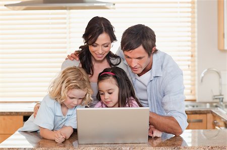 simsearch:400-04712944,k - Family using a notebook together in a kitchen Stock Photo - Budget Royalty-Free & Subscription, Code: 400-05749714