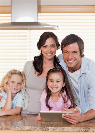 simsearch:400-05749726,k - Portrait of a smiling family using a tablet computer together in a kitchen Foto de stock - Super Valor sin royalties y Suscripción, Código: 400-05749720