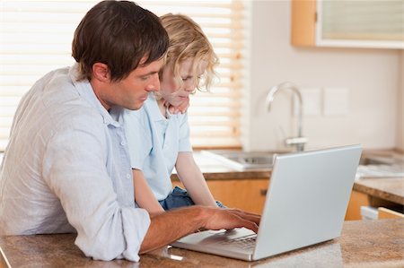 simsearch:400-04044122,k - Boy and his father using a laptop together in a kitchen Stock Photo - Budget Royalty-Free & Subscription, Code: 400-05749721