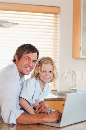 simsearch:400-04044122,k - Portrait of a boy and his father using a notebook together in a kitchen Stock Photo - Budget Royalty-Free & Subscription, Code: 400-05749723