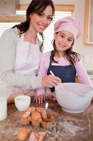 simsearch:640-01357998,k - Portrait of a happy mother baking with her daughter in a kitchen Stock Photo - Budget Royalty-Free & Subscription, Code: 400-05749752