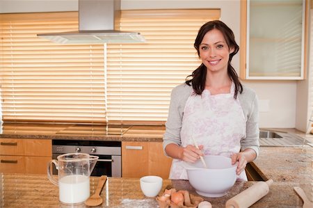 Smiling woman baking in her kitchen Stock Photo - Budget Royalty-Free & Subscription, Code: 400-05749766
