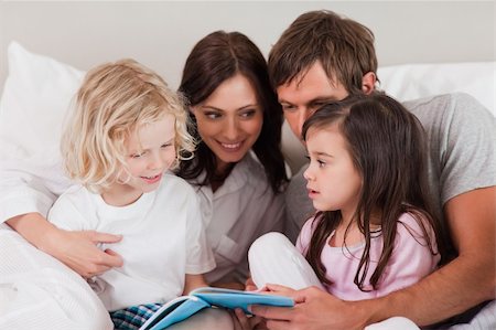 simsearch:400-05749479,k - Family reading a book in a bedroom Foto de stock - Royalty-Free Super Valor e Assinatura, Número: 400-05749779