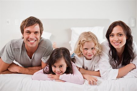 simsearch:400-04833477,k - Smiling family lying in a bed together Stock Photo - Budget Royalty-Free & Subscription, Code: 400-05749789