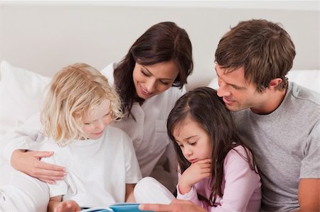 simsearch:400-05749645,k - Lovely family reading a book in a bedroom Stock Photo - Budget Royalty-Free & Subscription, Code: 400-05749780