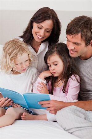 simsearch:400-05749645,k - Portrait of a family reading a book in a bedroom Stock Photo - Budget Royalty-Free & Subscription, Code: 400-05749781
