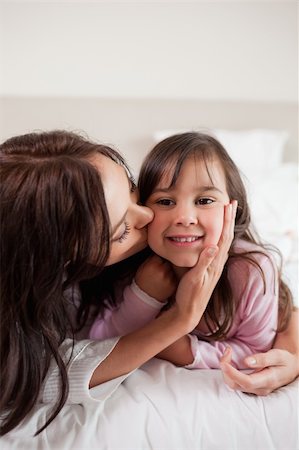 simsearch:400-05749479,k - Portrait of a mother kissing her daughter in a bedroom Foto de stock - Royalty-Free Super Valor e Assinatura, Número: 400-05749804