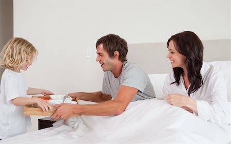 Lovely boy bringing breakfast to his parents in their bedroom Stock Photo - Budget Royalty-Free & Subscription, Code: 400-05749808